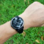 Explorer les objets portables et leurs possibilités montre au poignet dans l'herbe en arrière-plan